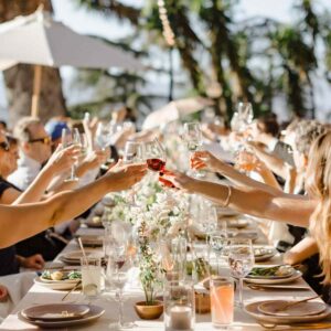 A group of people celebrating and raising their glasses in a beautifully decorated party venue.